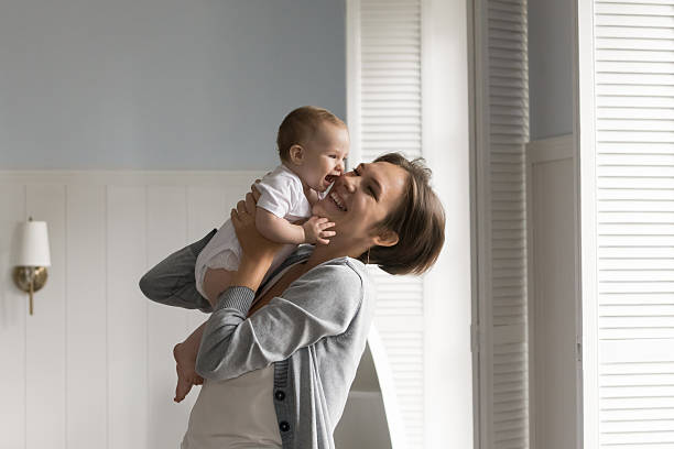 istock Happy affectionate young mom hug raise up small baby child 2235095783