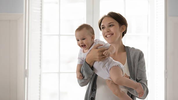 istock Happy excited little infant kid sit on caring mommy hands 2235095945