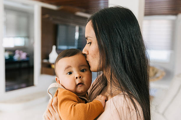 istock Mother holding baby at home 2235101720