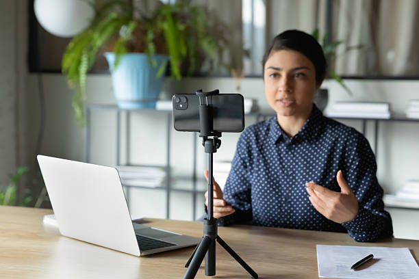 istock Serious Indian presenter girl, speaker talking at webcam on smartphone 2235102730