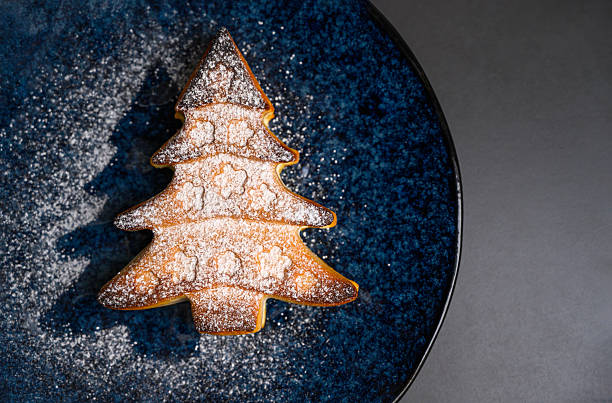 istock Christmas Tree Cookie with Powdered Sugar on Blue Ceramic Plate 2235103783