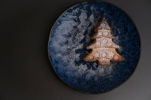 istock Christmas tree shaped cake with powdered sugar on dark plate. 2235103784