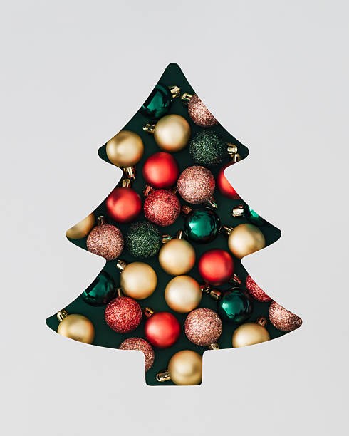 istock Winter composition with Xmas baubles visible through a Christmas tree shaped gap on green background. Minimal Christmas and New Year concept. Creative festive holiday layout. Flat lay, top view. 2235105868