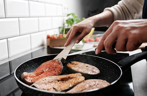 Red Fish Salmon Frying In A Pan On The Kitchen Stove