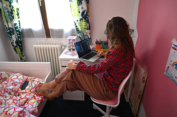 istock Woman working from home in child's bedroom using laptop 2235107307