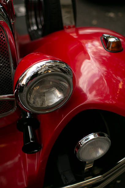 istock Closeup of a striking red car with a shiny chrome headlight 2235119735