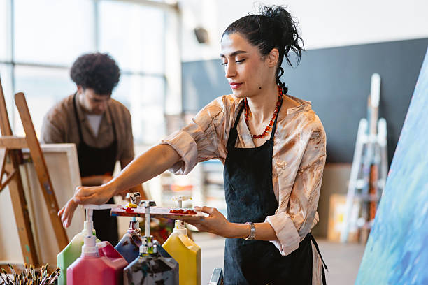 istock Cheerful Middle Eastern Female Mixing Paints in Art Studio 2235121425