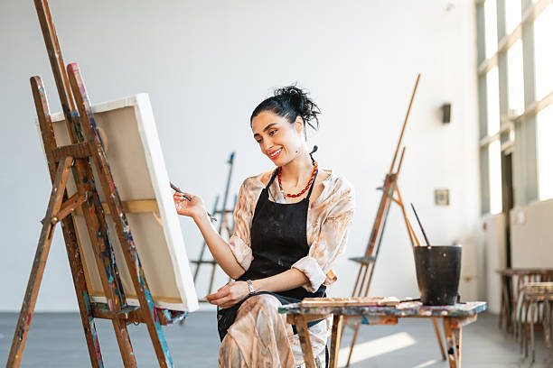 istock Young Female Artist Painting in Bright Modern Studio 2235121433