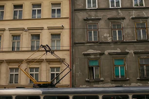 A trolley is currently parked in front of two distinct buildings, creating a scene that captures the urban landscape beautifully