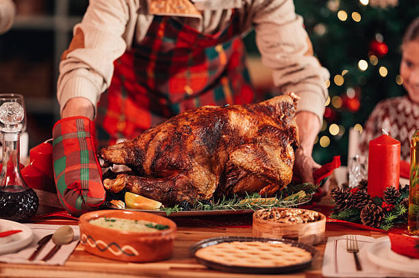 istock Chef placing roast turkey on christmas dinner table 2235128418