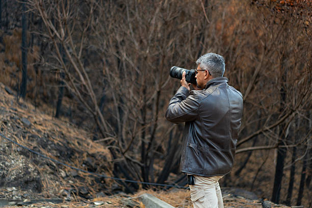 istock Photographer taking a picture of a burned forest 2235128874