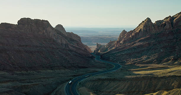 Aerial shot of winding road curving through Spotted Wolf Canyon, Emery County, Utah on a sunny day.