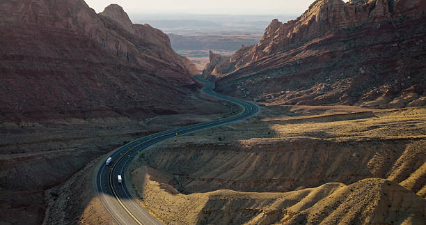 Aerial shot of winding road curving through Spotted Wolf Canyon, Emery County, Utah on a sunny day.