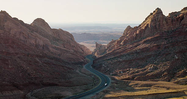 Aerial shot of winding road curving through Spotted Wolf Canyon, Emery County, Utah on a sunny day.