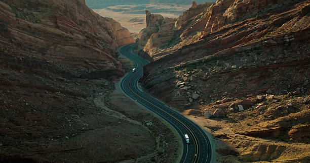 Aerial shot of winding road curving through Spotted Wolf Canyon, Emery County, Utah on a sunny day.