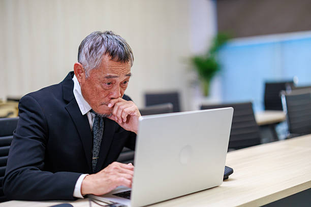 istock Stressful senior businessman working with laptop in modern office while facing corporate pressure and financial challenges highlighting workplace stress management and business strategy issues 2235130226