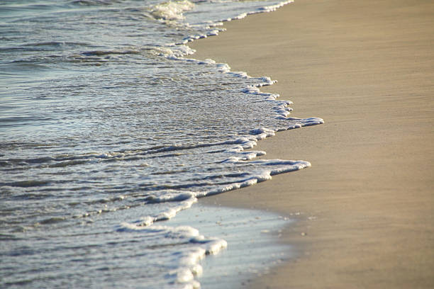 istock Close-up of surf on sandy beach 2235131969