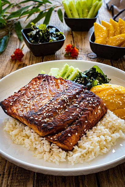istock Seared teriyaki salmon steak with white rice on wooden table 2235140936