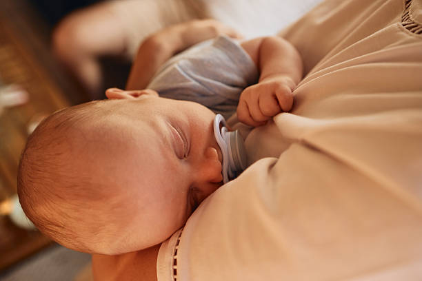 istock Young mother is holding her newborn sleeping baby 2235143557