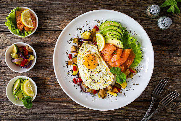istock Smoked salmon with sunny side up egg, avocado and vegetables on wooden table 2235144090