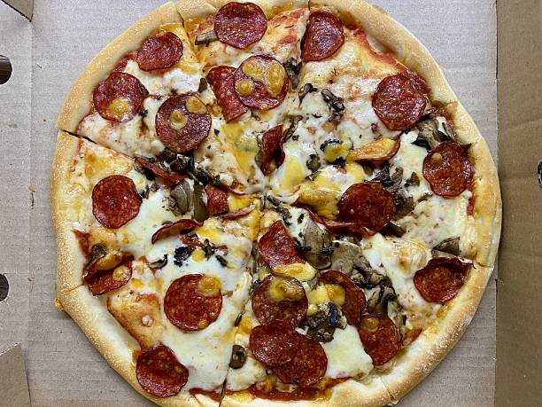 istock Top view of sliced pepperoni pizza in a box on the table 2235145185