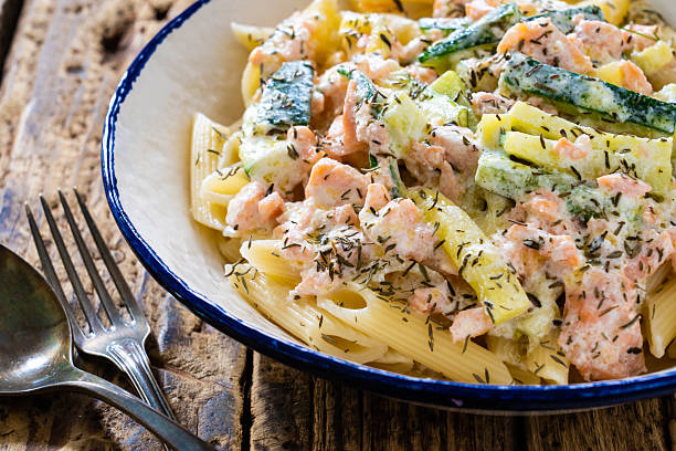 istock Pasta with salmon and vegetables on wooden table 2235147943