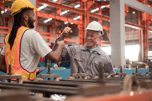 istock Senior engineers and young man workers are talking and inspecting machines on a production line 2235153501
