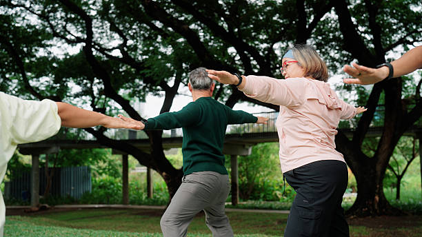 istock Senior group performing yoga exercises outdoors in a public park 2235158318