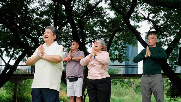 istock Senior group performing yoga exercises outdoors in a public park 2235158357