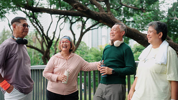 istock Active elderly people resting, smiling, and chatting together in the park 2235158358