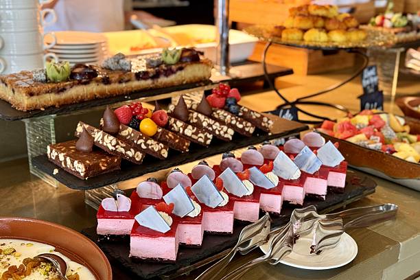 The portions of chocolate, red and different cakes with berries on a black stands