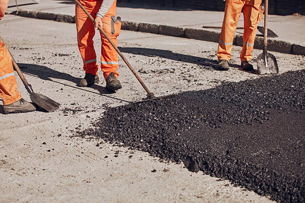 istock Construction workers working on a new asphalt layer on a public street. 2235159489