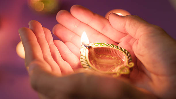 istock hand carrying glowing festival diya 2235162788