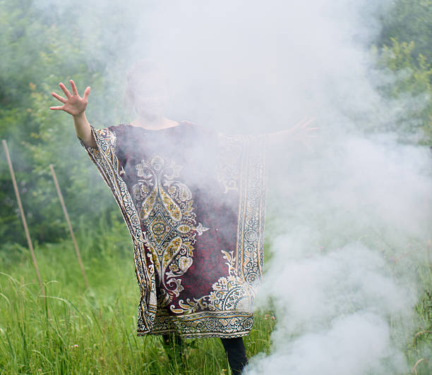 istock A cheerful girl dispersing thick smoke from a fire with her hands 2235164999