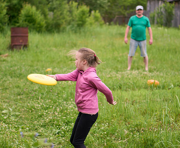 istock Cute girl throwing plastic disc to her dad at picnic 2235165484