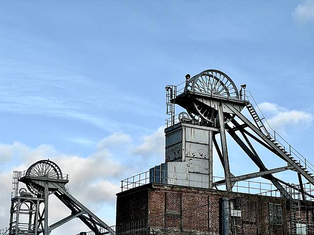 Two disused pit head wheels against cloudscape in Northumberland