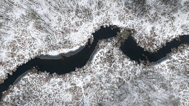 istock Flying above white forest and small river in winter. 2235171268