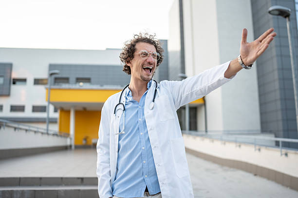 istock Cheerful Doctor Outside Modern Hospital Gesturing Positively 2235174120
