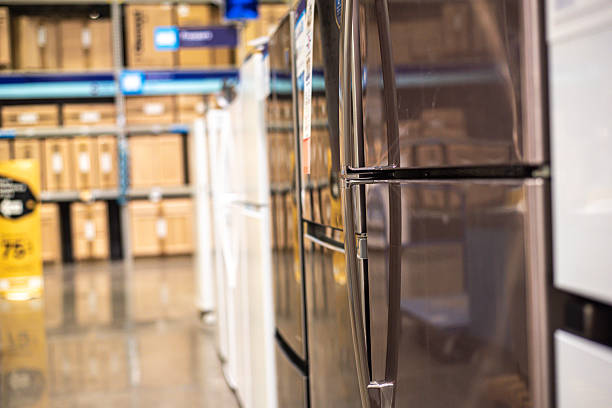 istock Top-freezer and side-by-side refrigerators lined up in showroom with polished concrete floor in Dallas, TX. Bright lighting, blurred shelves create clean, modern retail atmosphere big box store 2235174394