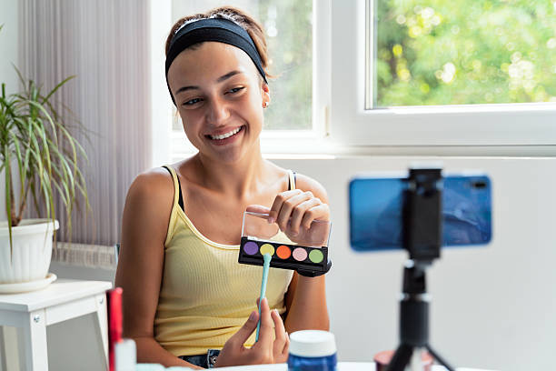 istock Smiling girl applying colorful eyeshadow in sunlight 2235177620