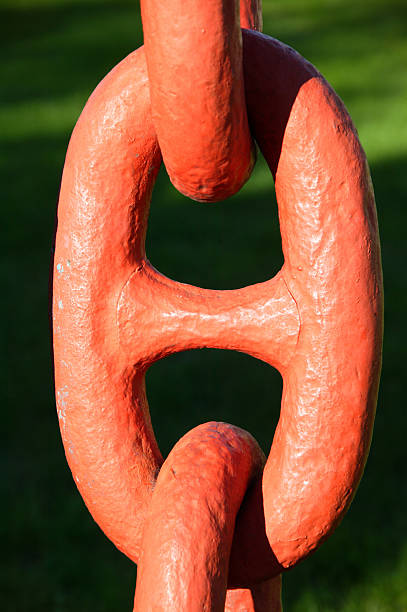 istock Close up link from a large nautical orange iron anchor chain under stress 2235178693