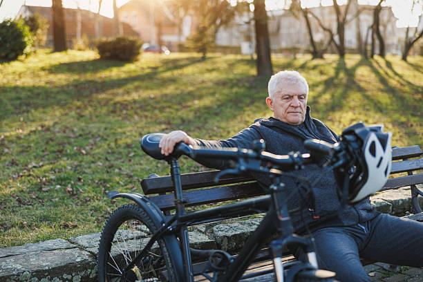 istock Man Sitting on Bench Next to Bike 2235180506