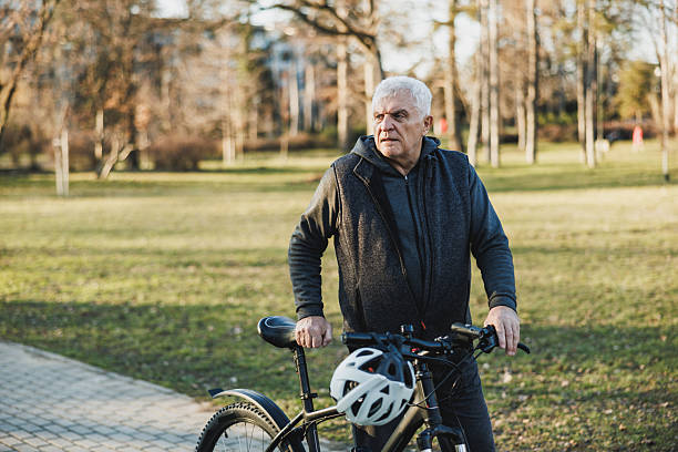 istock Man Walking a Bike Down a Sidewalk In City Park 2235180721