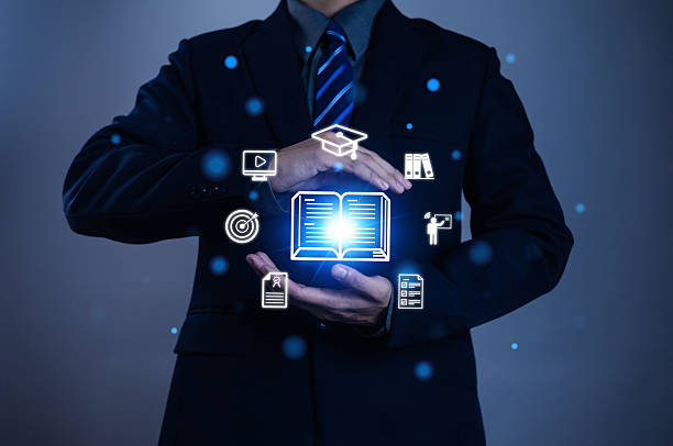 istock Businessman holding digital book icon with education symbols, representing e-learning, online study, knowledge sharing, academic success, digital training, modern education, learning concept. 2235180781