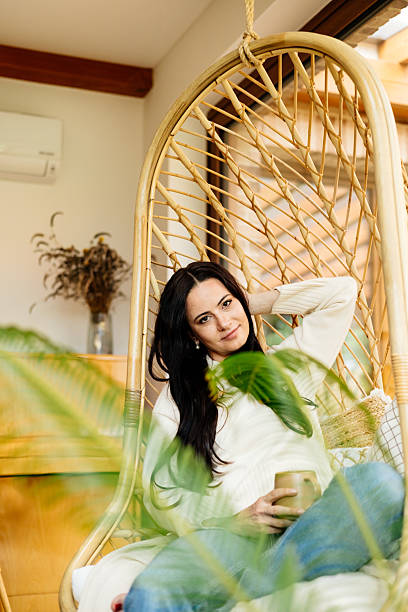 istock Relaxed woman taking a break, sitting on carpet and drinking coffee. 2235181678