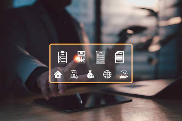 istock Businessperson's hand interacts virtual interface displaying tax management icons. Digital documents, calculator, financial planning tools assist economic compliance. Modern technology streamlines 2235181863