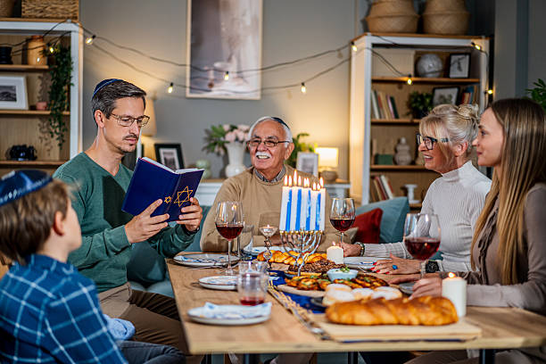 istock Family celebrating Hanukkah reading from the torah at dinner table 2235193859