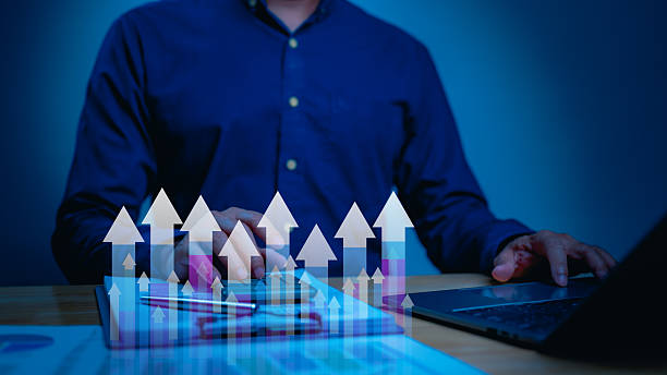 istock Blue Laptop Analysis Professional ROI Improvement Presented Upward Gradient Arrows, Document Focus, Showcasing Growth Dim, Modern Work Environment 2235195907