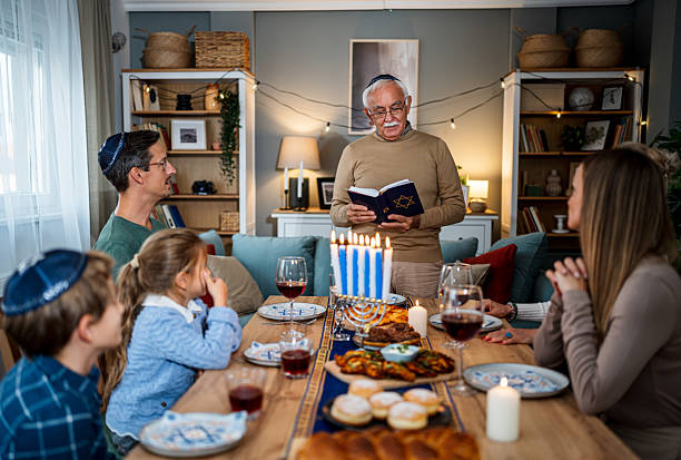 Extended family celebrating Hanukkah with traditional dinner and prayers