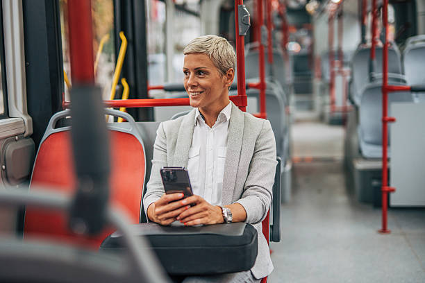 istock Businesswoman using smartphone while riding bus to work 2235197035